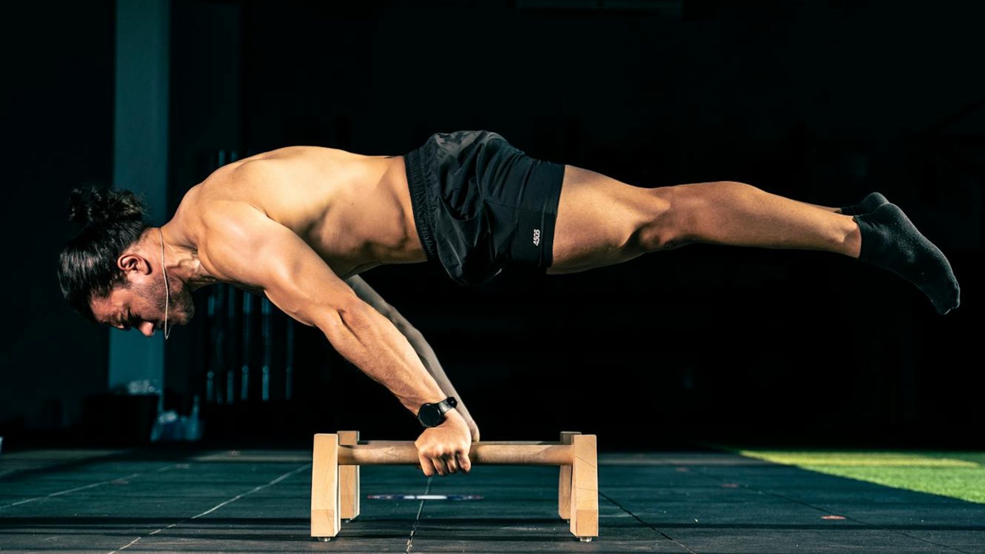 Man performing a controlled strength exercise in a minimalist gym.